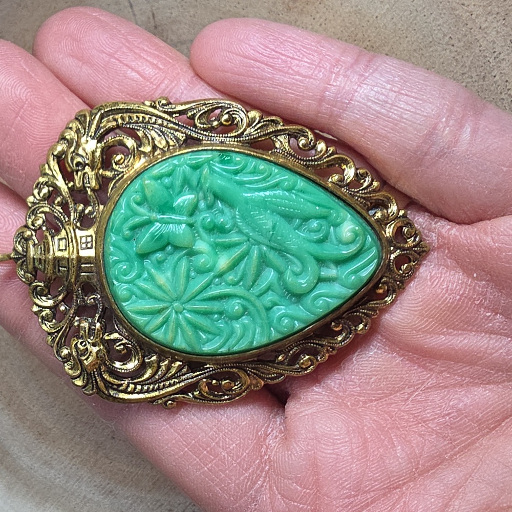 Vintage gold-tone Asian-style brooch/pendant featuring a carved green celluloid